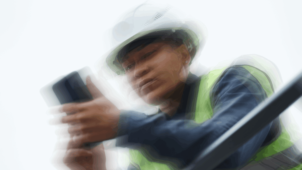 Construction worker in high-vis gear using a smartphone