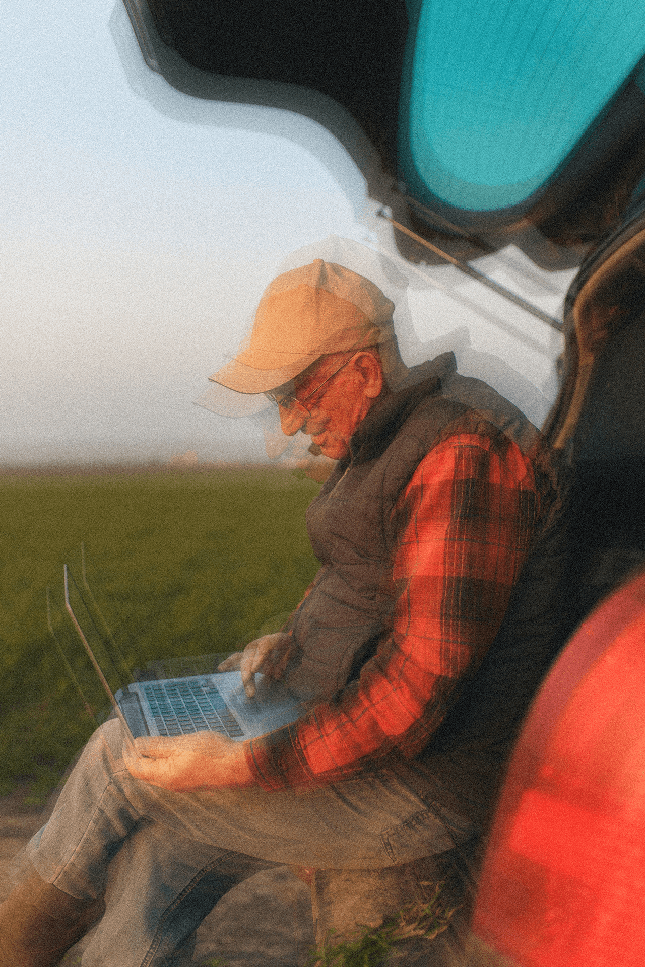 person in field with laptop