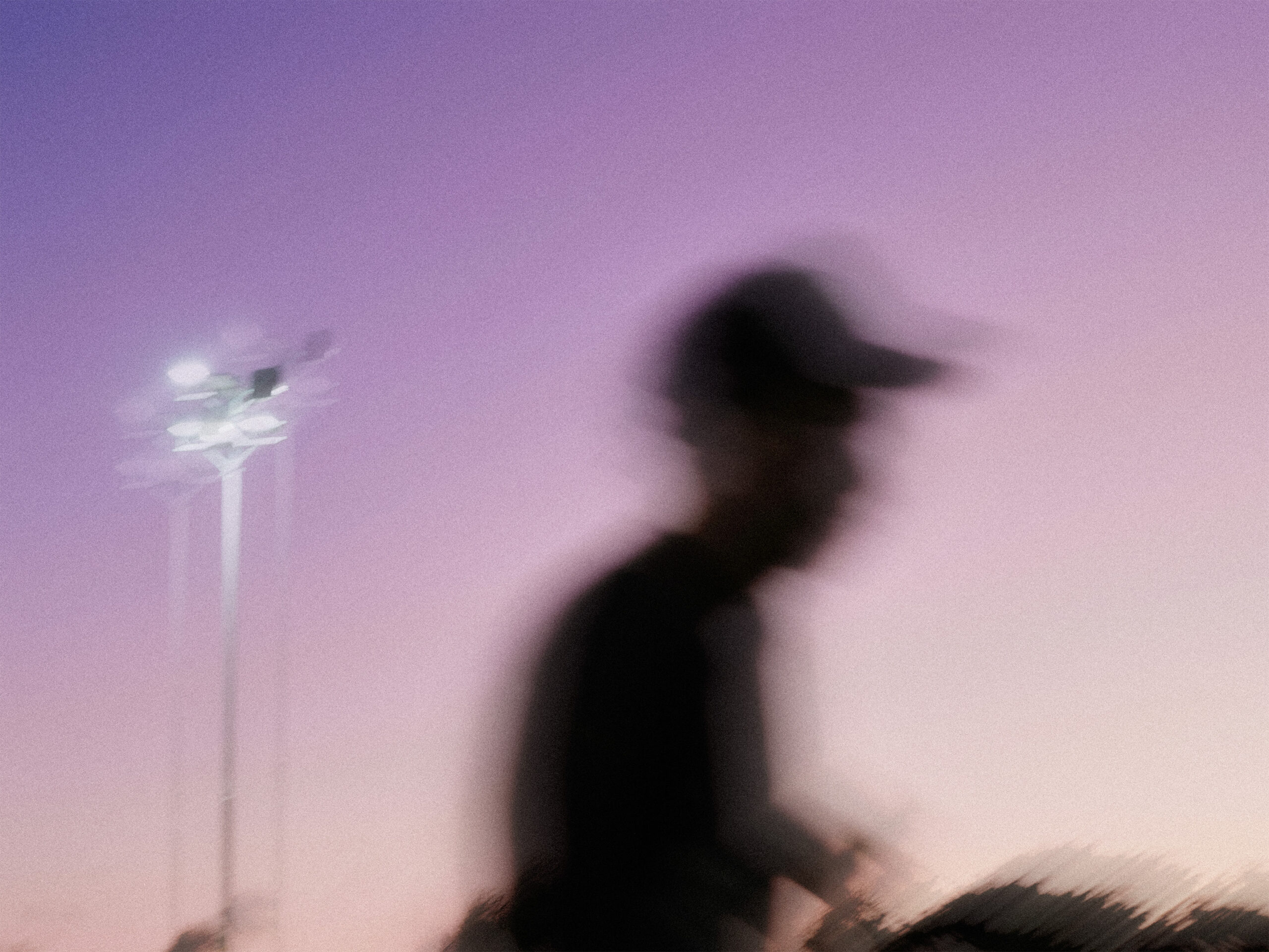 abstract image of person with hat and purple sunset looking back drop